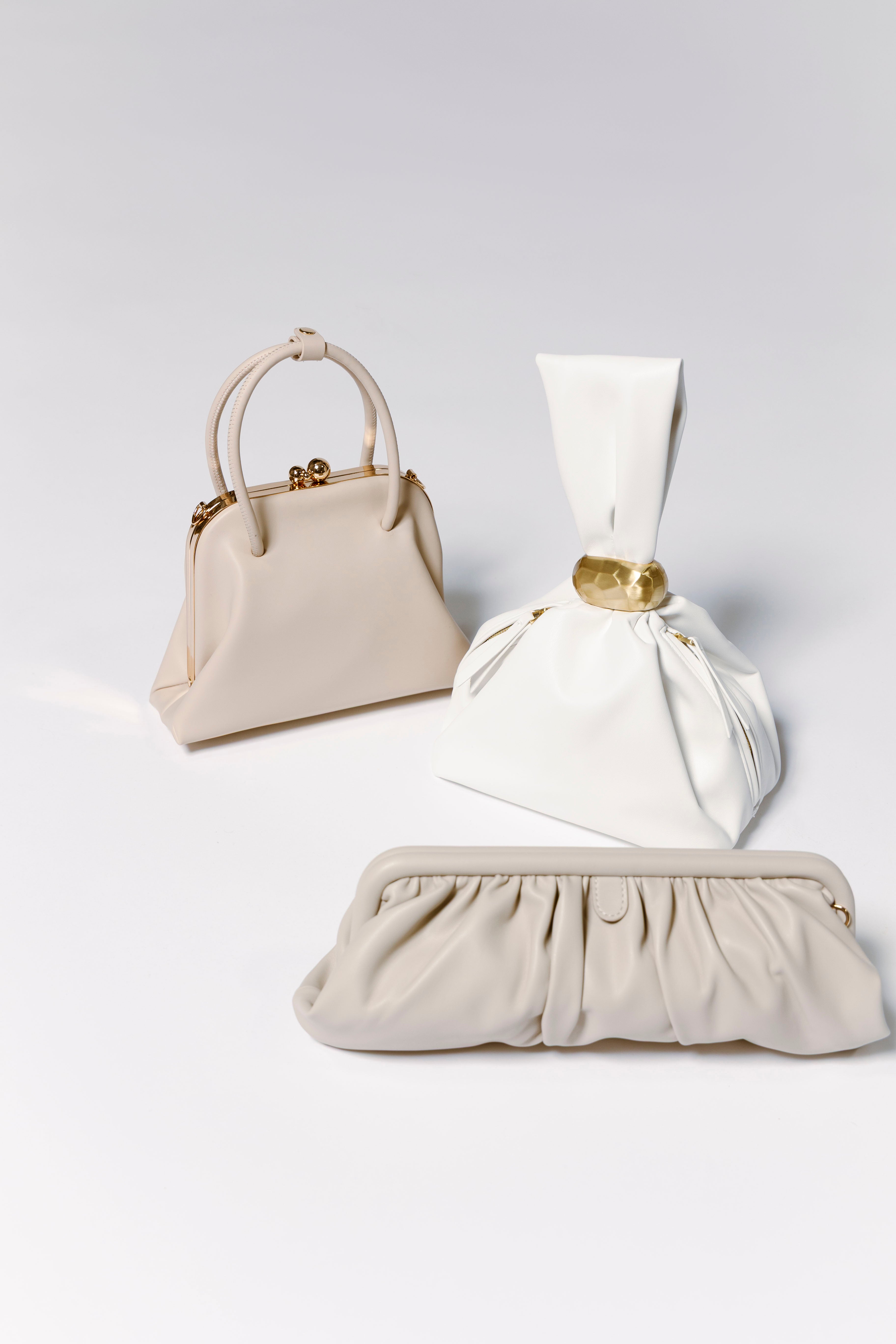 tan and white evening handbags with a link to shop all handbags
