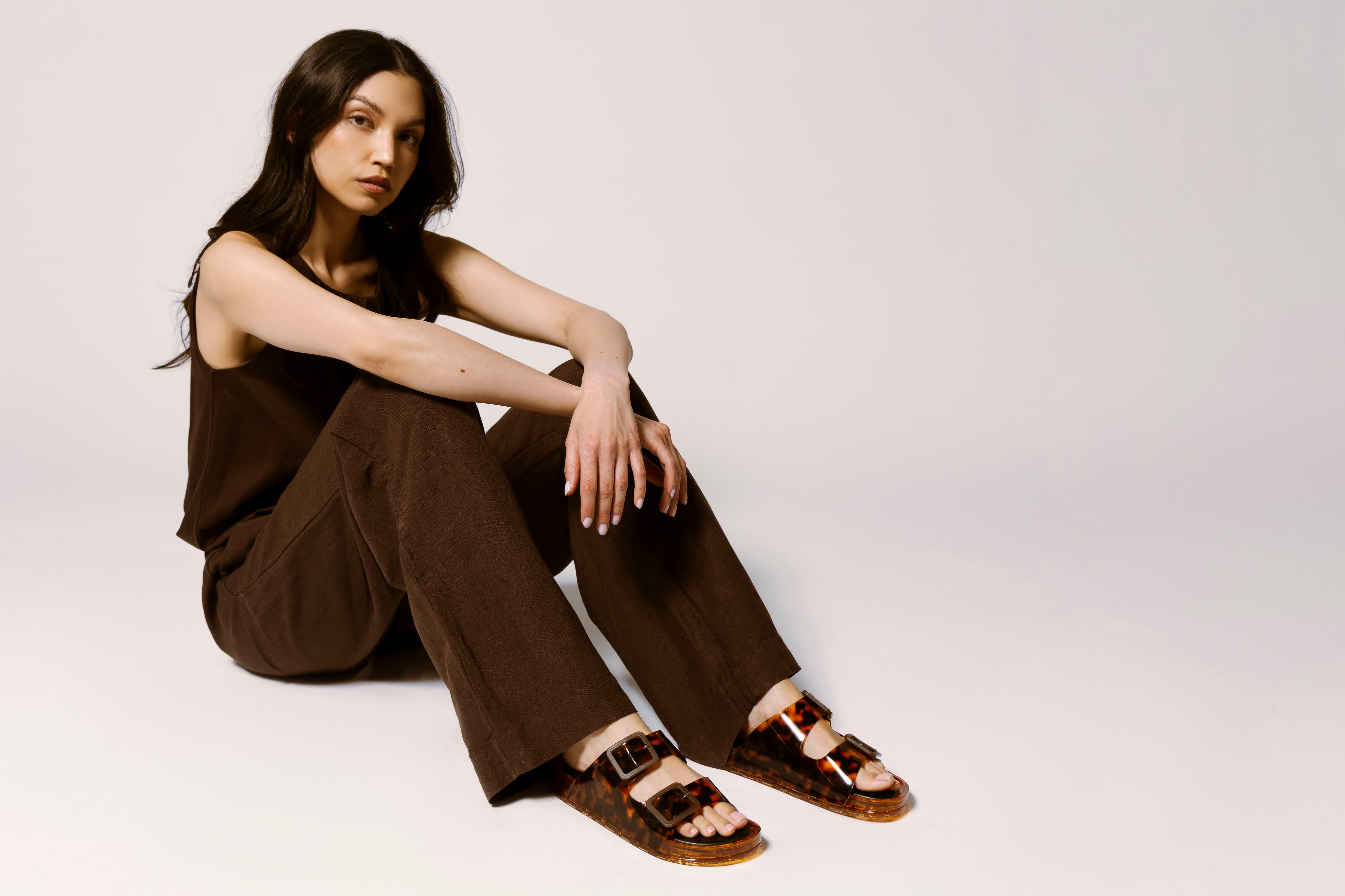 woman wearing all brown outfit and tortoise jelly sandals with link to shop the julio by dolce vita
